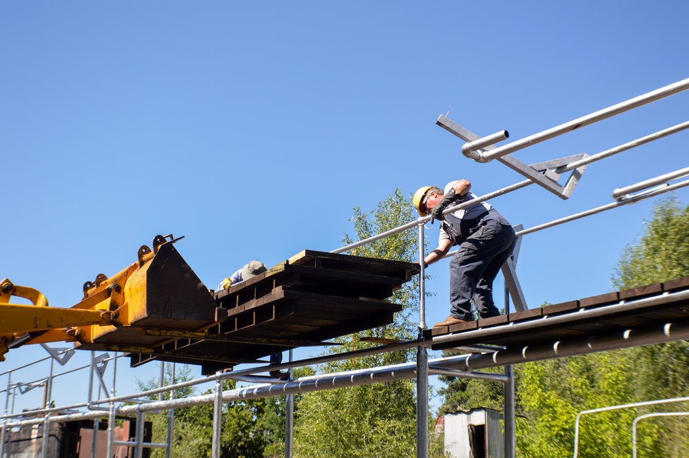 12 Using a fork attachment on the loader to get the new decking on the Gramps Oil loading rack.jpg