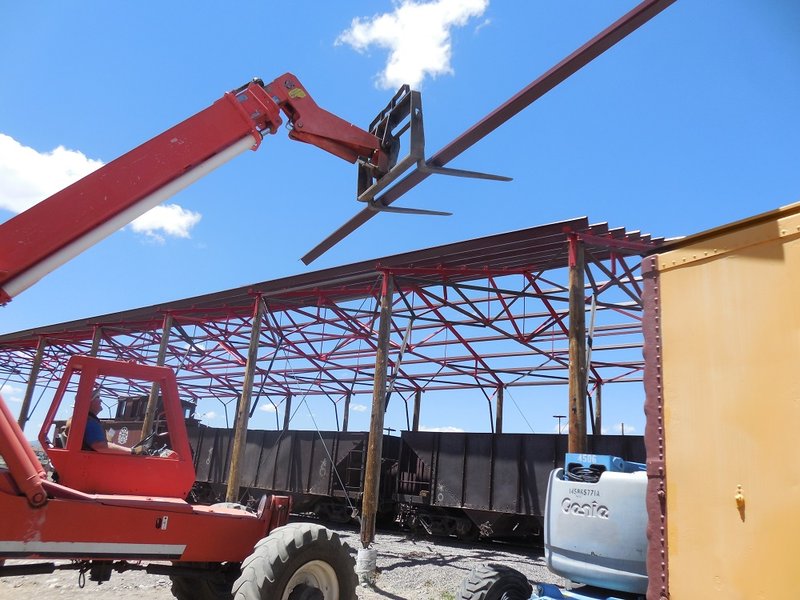 John Engs hoists purlin (rafter) up to roof structure of Car Shelter.jpg