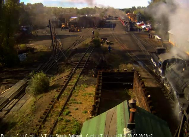 2018-09-02 One member of the 488 crew has gotten on board and is washing the locomotive down while the other waits by the sand crib to keep from getting wet.jpg