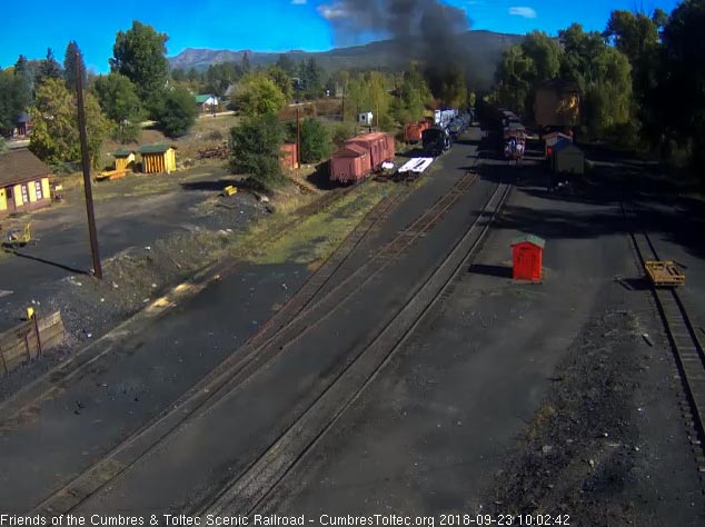 2018-09-23 The locomotives are exiting the yard as the caboose passes the tank.jpg