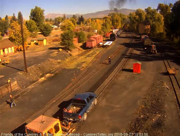 2018-09-27 The last cars are entering the curve as some men pull up to unload a speeder.jpg